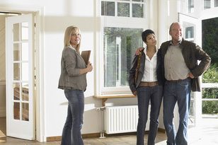 Immobilienmaklerin bei der Besichtigung mit älterem Paar