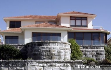 Große Villa mit hohen Fenstern und Steinmauern