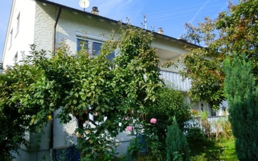 Wohnhaus mit hoch gewachsenen Bäumen im Vorgarten