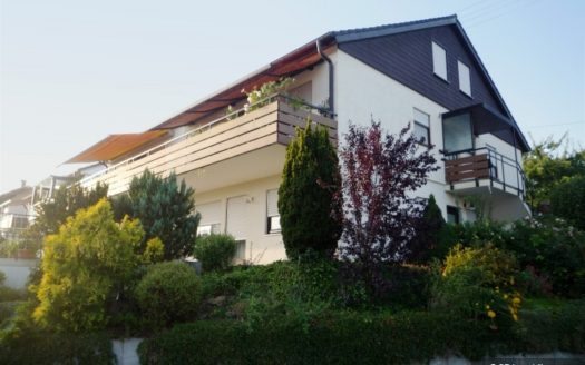 Haus mit schwarzer Giebelverkleidung und weitläufigem Balkon