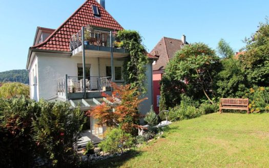 Einfamilienhaus mit schön dekorierten Balkonen und großem Garten