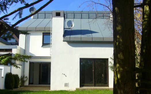 Ansicht vom Garten auf Terrasse und Blechdach mit Satellitenschüssel