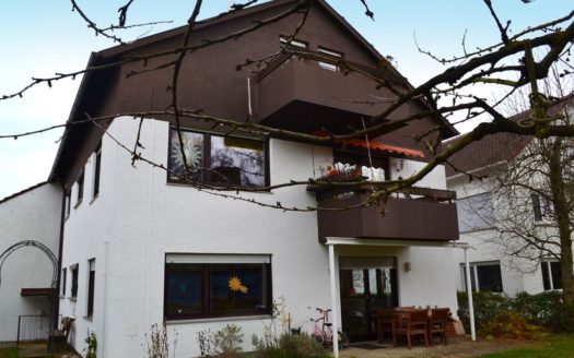 Einfamilienhaus mit braunem Giebel und Balkonen