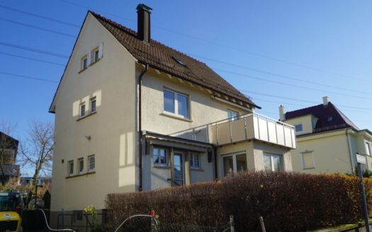 Einfamilienhaus mit Balkon und Hecke