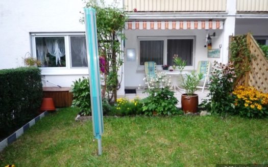 Garten mit Wäschespinne und Blick auf Terrasse mit Markise