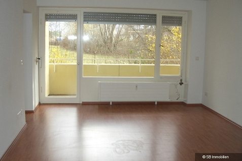 Unmöbliertes Zimmer mit Fensterfront und Balkontüre