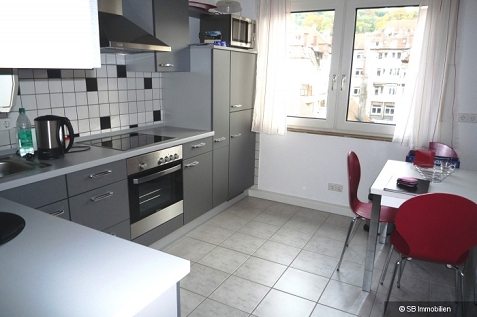 Moderne, geräumige Küche in Dunkelgrau mit Frühstückstisch