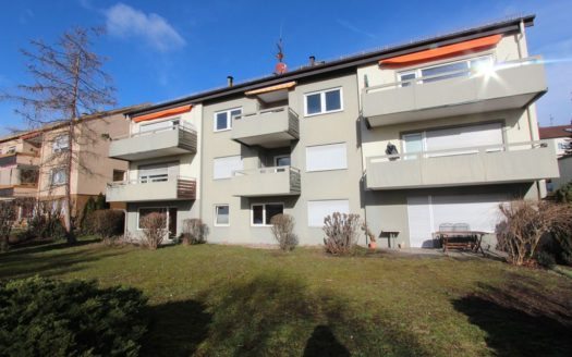 Mehrparteienhaus mit breiten, grau gestrichenen Balkonen