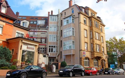 Umgebung eines Wohnhauses mit geparkten Autos und einem Bäcker