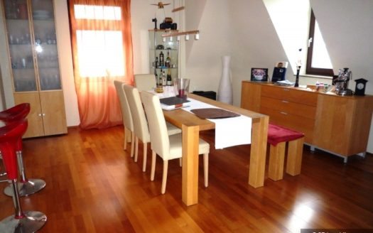 Länglicher Esstisch mit Bank und Stühlen und Barhocker im Hintergrund