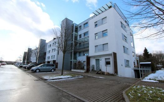 Hell gestrichener Appartementkomplex mit Stellplätzen