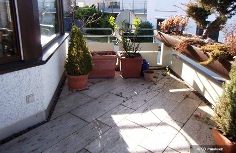 Verwinkelter Steinplattenbalkon mit Kübelpflanzen