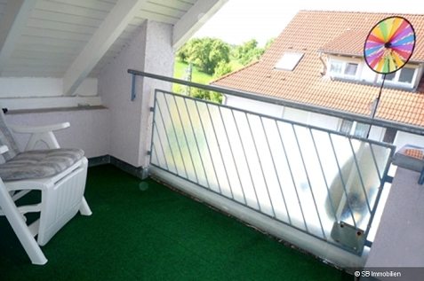 Dachbalkon mit Sichtschutz aus Glas und grünem Rasenteppich