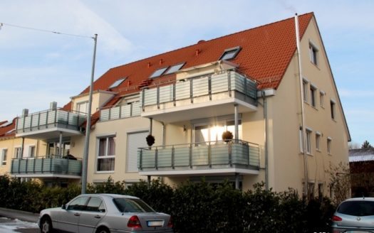 Blick auf Wohnhaus mit breiten Balkonen und rot gedecktem Dach