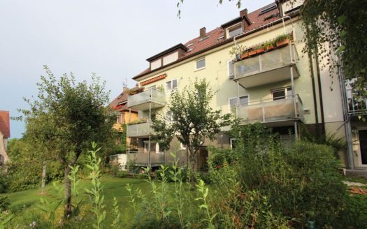 Wohnhaus mit mehreren Balkonen und gepflegtem Garten