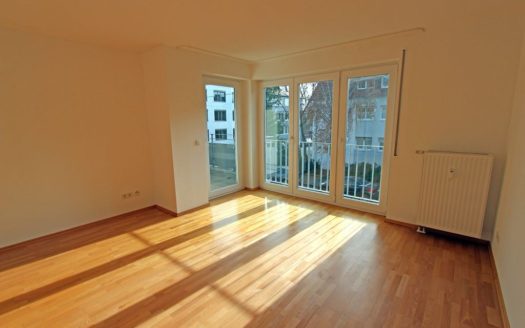 Heller Laminat und bodentiefe Fenster in Zimmer mit Balkonzugang